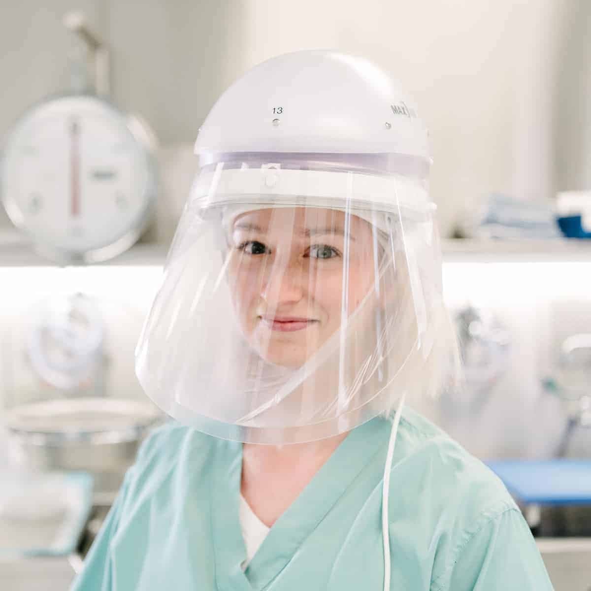 Healthcare worker wearing a Powered Air-Purifying Respirator (PAPR) with a hood